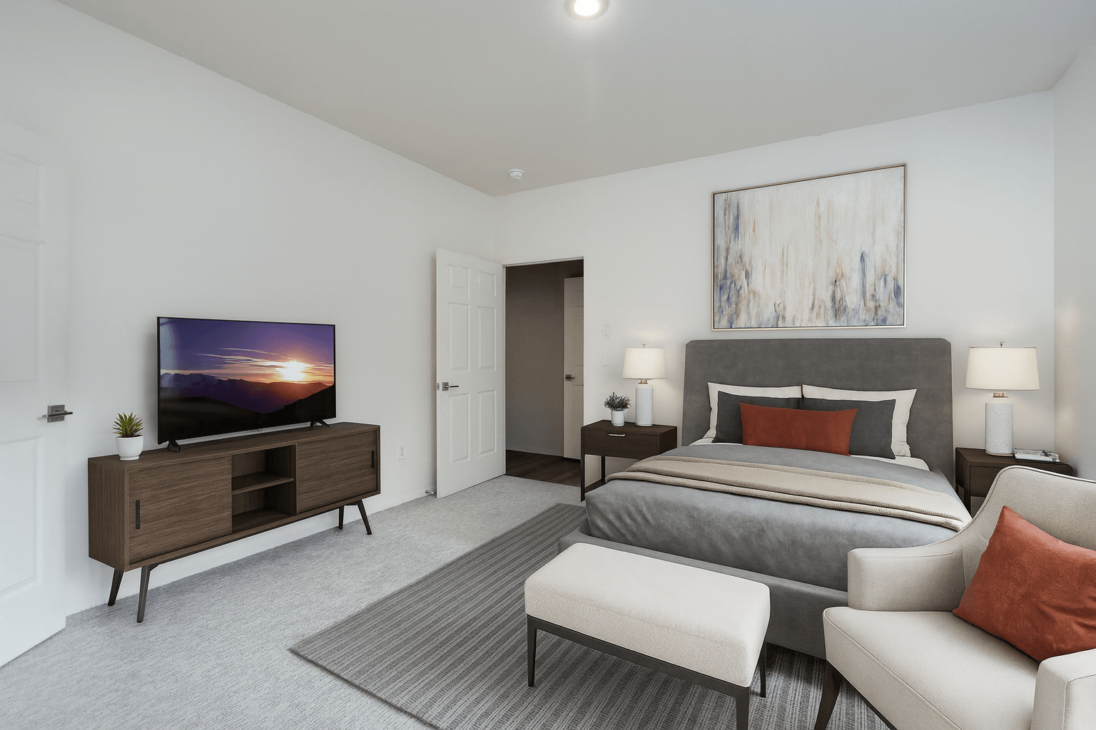 A bedroom with a large bed, a couch, and a television.